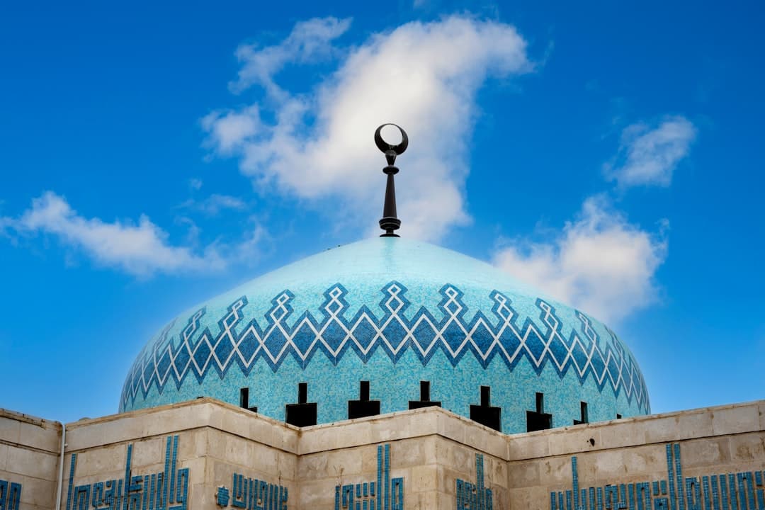 The blue mosaic dome of King Abdullah I Mosque against a clear sky