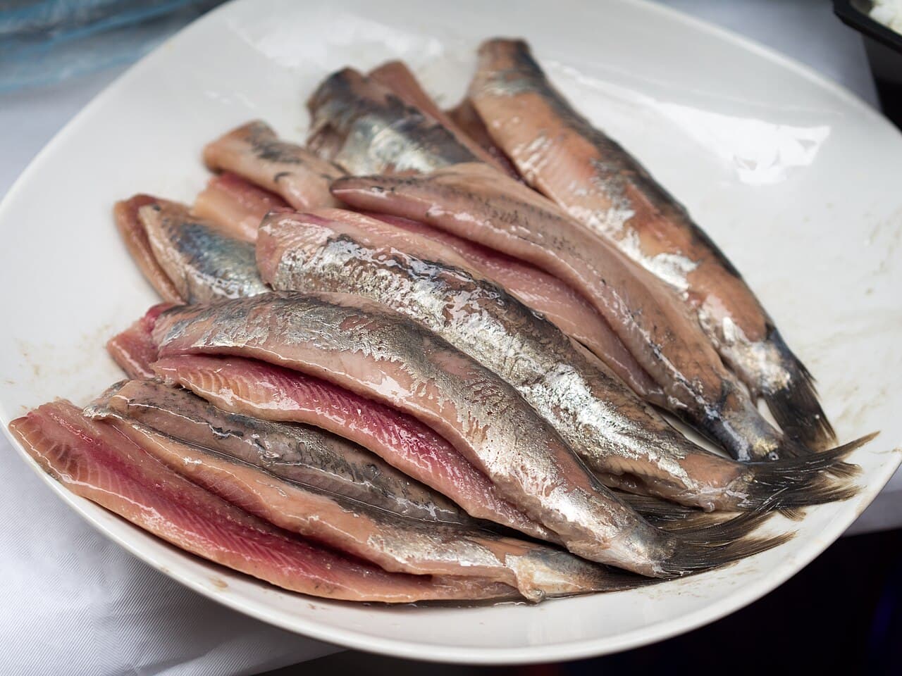 A portion of raw herring with chopped onions and pickles at a fish stand