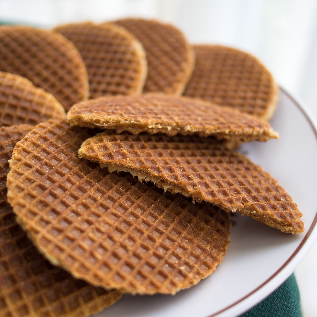 A fresh stroopwafel being pressed on a waffle iron at a market stall
