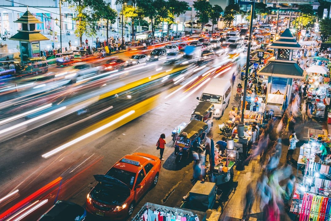 Colourful light trails and stalls at a Bangkok night market