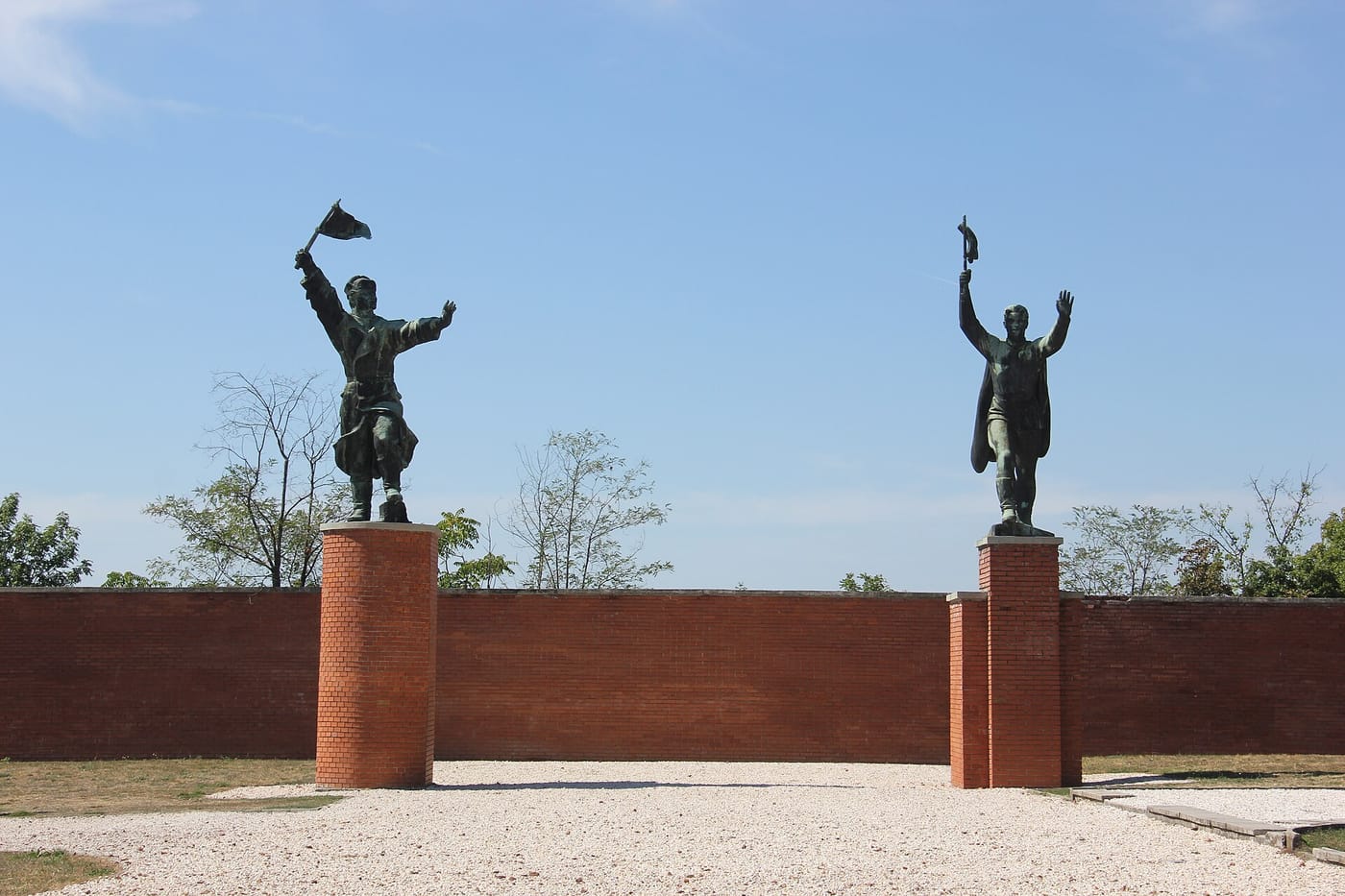 Two giant communist-era statues with raised arms at Memento Park, Budapest