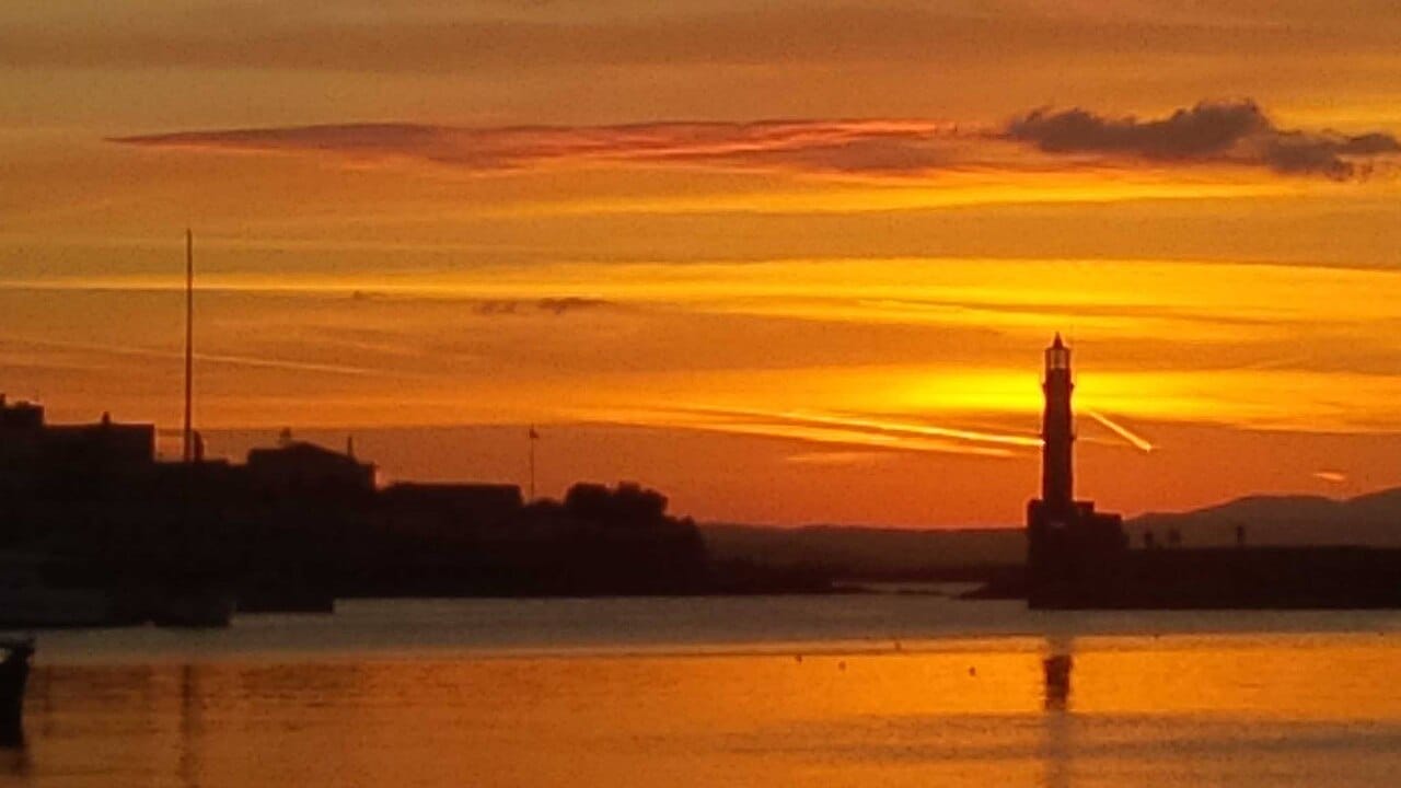 Sunset over the harbour bars of Chania