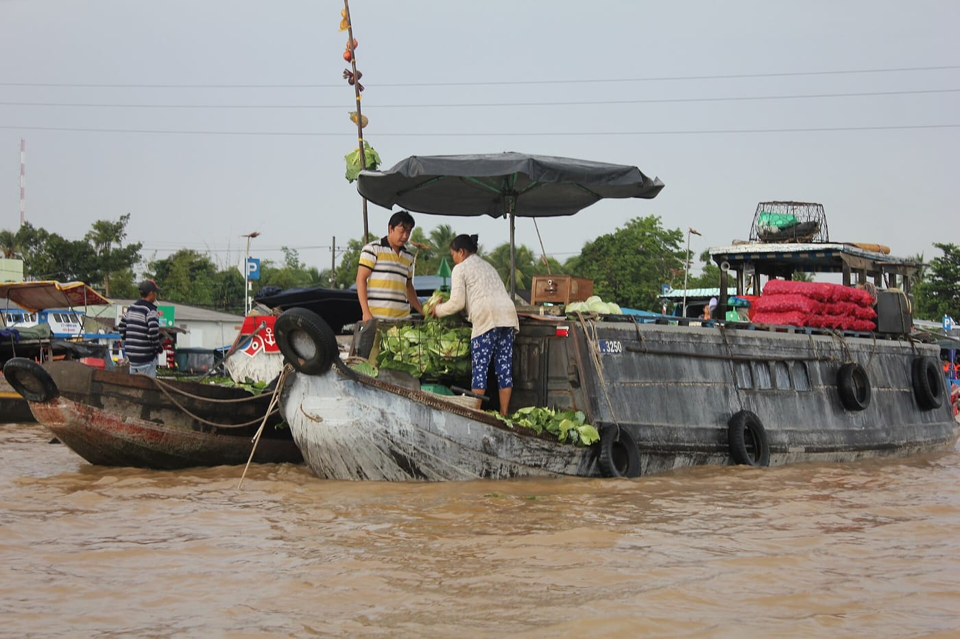 A wooden boat on a river at a floating market in the Mekong Delta