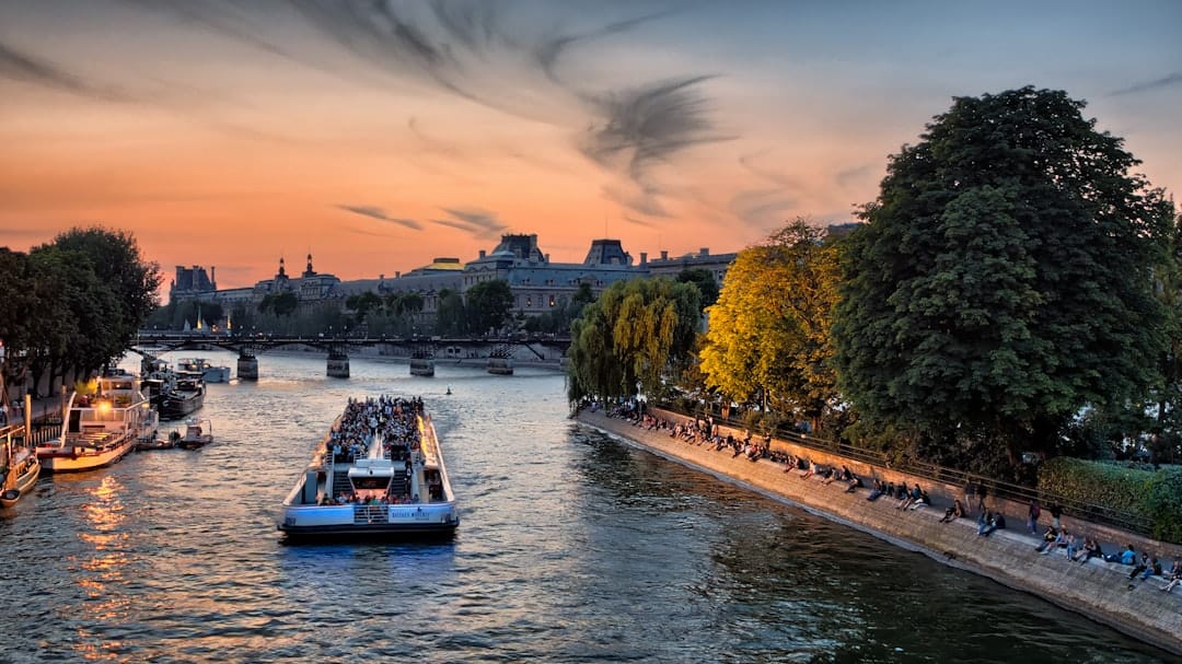 The Seine glowing at sunset beside the Pont Neuf as a tour boat passes