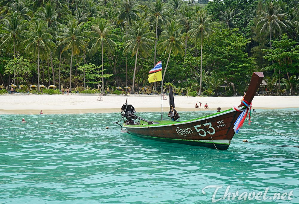 A longtail boat on the turquoise water of Freedom Beach, Phuket
