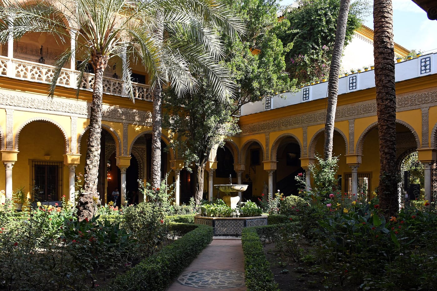 A palm-filled courtyard in the Palacio de las Dueñas in Seville