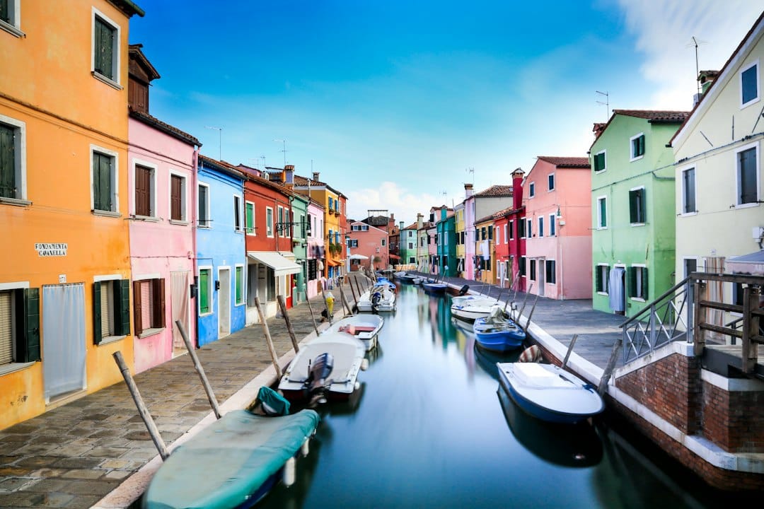Brightly coloured houses reflected in a canal on the island of Burano, Venice