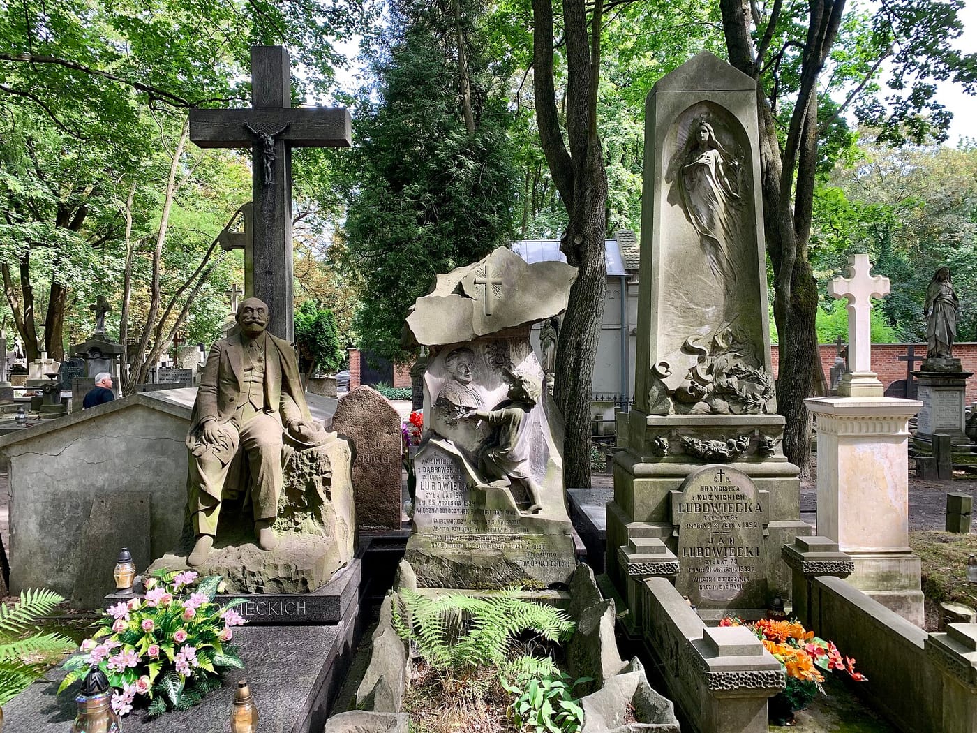 Moss-covered statues and tombs in Powązki Cemetery, Warsaw